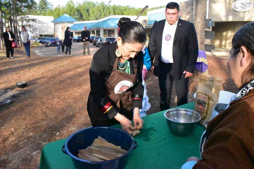 Mississippi Band of Choctaw Indians Tribal Chief Cyrus Ben looks on as Secretary of the Interior Deb Haaland makes traditional Choctaw food Banaha.